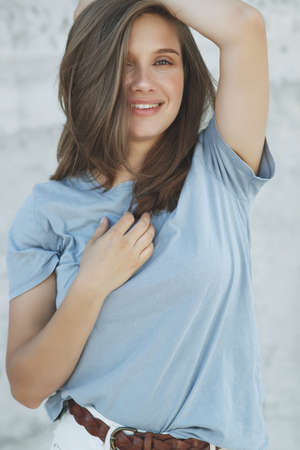Portrait of cheerful mature woman standing against grey wall. Smiling carefree woman looking at camera. High quality photo.の写真素材