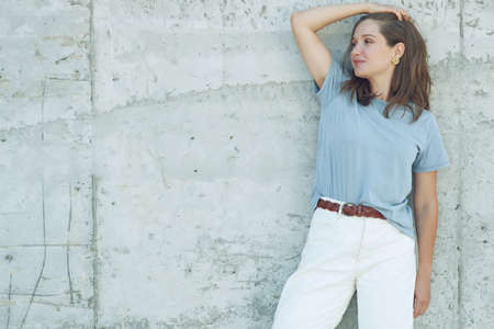 Portrait of cheerful mature woman standing against grey wall. Smiling carefree woman looking at camera. High quality photo.の写真素材