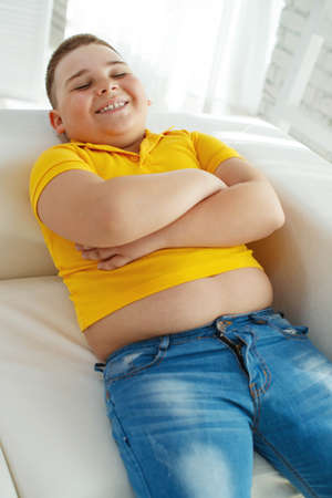 A boy with metabolic disorders. Child with the problem of childhood obesity. Overweight obese fat boy. High quality photo.の写真素材