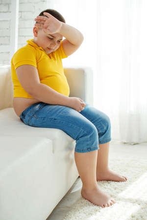 A boy with metabolic disorders. Child with the problem of childhood obesity. Overweight obese fat boy. High quality photo.の写真素材