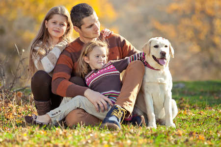 Family resting in nature in autumn. Beautiful woman with a man have fun playing with children. High quality photo.の写真素材