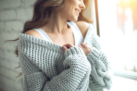 Young beautiful woman in warm knitted clothes at home. Female indoor portrait. High quality photo.の写真素材