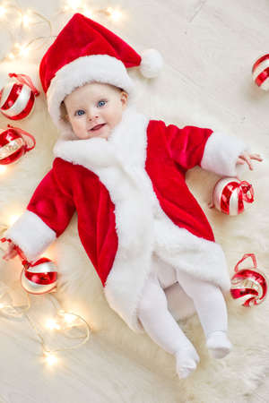A beautiful little child is celebrating Christmas. New Years Holidays. Child in a Christmas costume with a gift. High quality photo.の写真素材