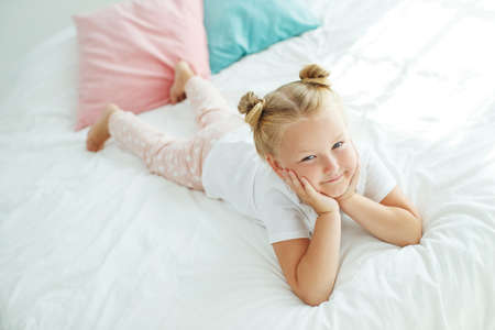 Nice baby girl enjoys a sunny morning. Good morning at home. The girl wakes up from sleep. High quality photo.の写真素材