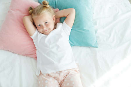 Nice baby girl enjoys a sunny morning. Good morning at home. The girl wakes up from sleep. High quality photo.の写真素材