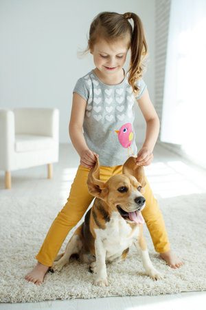 Little girl with a dog at home. High quality photo.の写真素材