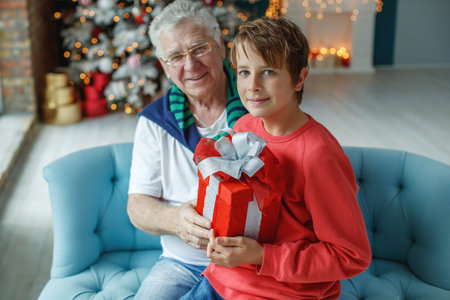 Grandfather and grandchildren in a room decorated for Christmas against the background of a Christmas tree. Christmas holiday concept. contrast photography. High quality photo.の写真素材