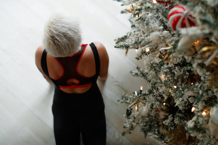 Portrait of gorgeous young woman practicing yoga indoors at Christmas time. Beautiful girl practice in the class. High quality photo.の写真素材