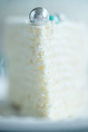 Vanilla sponge cake with cream and white chocolate decorate. Sliced piece of cake on white plate. Favorite dessert for celebrate event or birthday party. High quality photo.の写真素材