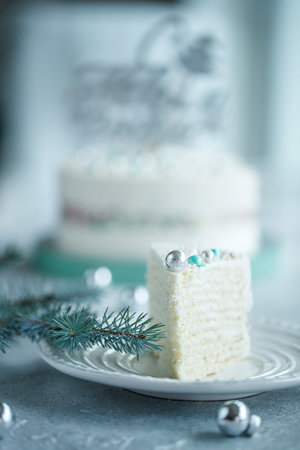 Vanilla sponge cake with cream and white chocolate decorate. Sliced piece of cake on white plate. Favorite dessert for celebrate event or birthday party. High quality photo.の写真素材