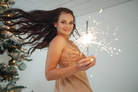A woman with a sparkler at Christmas. High quality photo.の写真素材