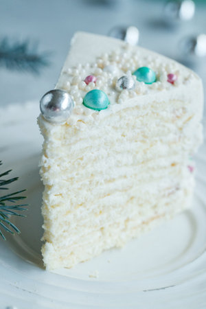 Vanilla sponge cake with cream and white chocolate decorate. Sliced piece of cake on white plate. Favorite dessert for celebrate event or birthday party. High quality photo.の写真素材