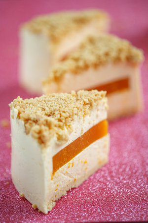 A slice of cheesecake with tangerine filling.の写真素材