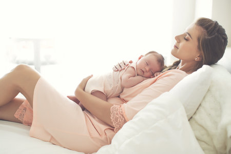 Portrait of a beautiful mother, with her nursing baby. High quality photo.の写真素材