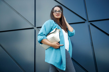 Beautiful stylish overweight woman with mobile phone outdoors. High quality photo