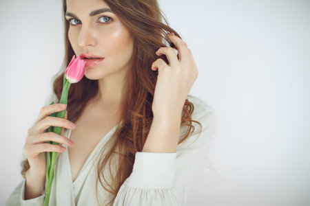 Beautiful woman with tulips. Spring bouquet in the hands of a young and happy girl. High quality photo.の写真素材