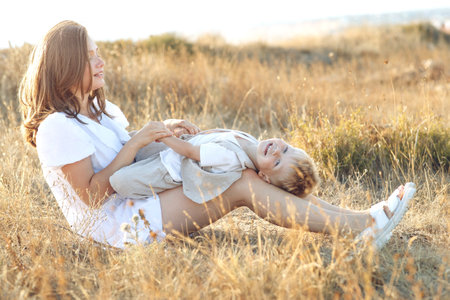 Mother and little child are playing together in the park. High quality photo.の写真素材