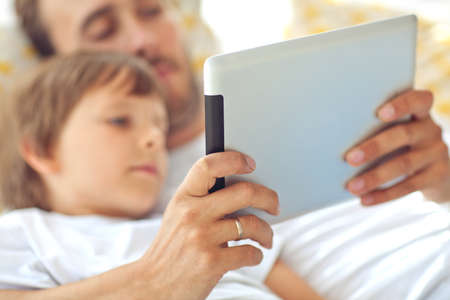 Son and father are playing a computer game on a tablet. . High quality photoの写真素材
