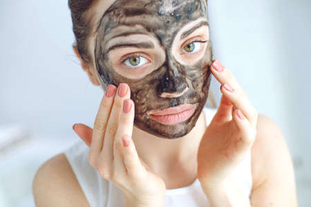 Woman with cosmetic mask on her face. The daily routine is facial cleansing, skin care, exfoliation, moisturizing. High quality photo.の写真素材