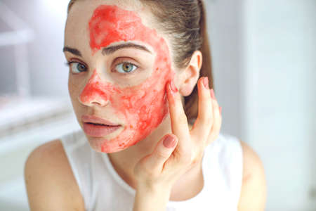 Woman with cosmetic mask on her face. The daily routine is facial cleansing, skin care, exfoliation, moisturizing. High quality photo.の写真素材