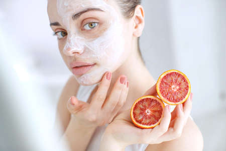 Woman with cosmetic mask on her face. The daily routine is facial cleansing, skin care, exfoliation, moisturizing and beauty treatments. High quality photo.の写真素材