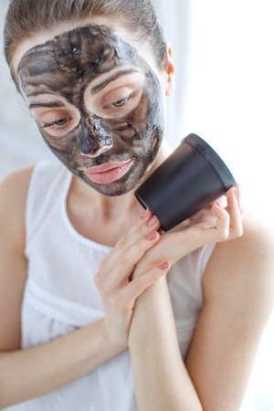 Woman with cosmetic mask on her face. The daily routine is facial cleansing, skin care, exfoliation, moisturizing and beauty treatments. High quality photo.の写真素材