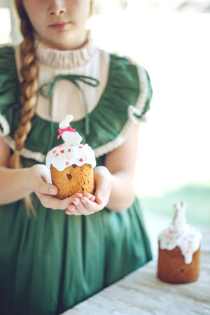 The child is holding an Easter cake. Birthday cake. High quality photo.