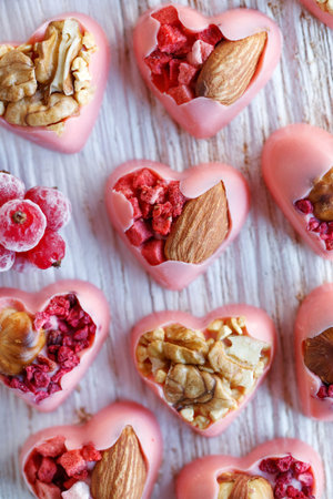 Delicious chocolate candies on a wooden background. Heart shaped sweets. High quality photo.