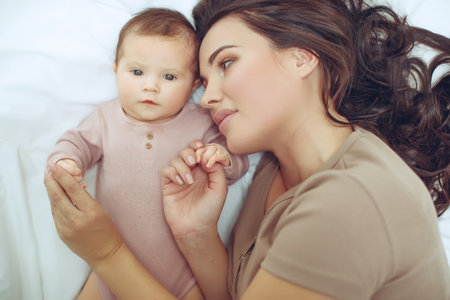 A young mother is holding her newborn baby. Mother of a nursing baby. Mother breastfeeding her baby. The family is at home. Portrait of a happy mother and child. High quality photo.の写真素材