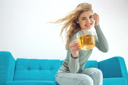Young woman sitting at home and drinking tea, interior. High quality photo.の写真素材