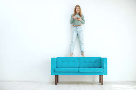 Young woman sitting at home and drinking tea, interior. High quality photo.の写真素材