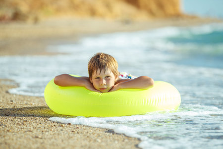 Boy child has fun at sea. Summer, happiness, sea and a child with a ball. High quality photo.の写真素材