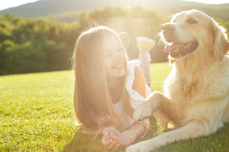 Teenager girl with a dog in nature. High quality photo.の写真素材