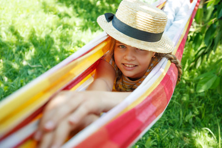 Summer vacation - lovely girl in a colorful hammock. High quality photoの写真素材