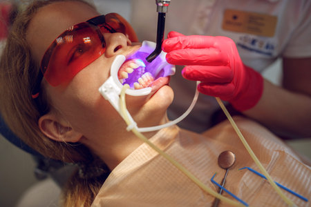 Teenage girl with braces visiting the orthodontist at the clinic. Installation of braces system....