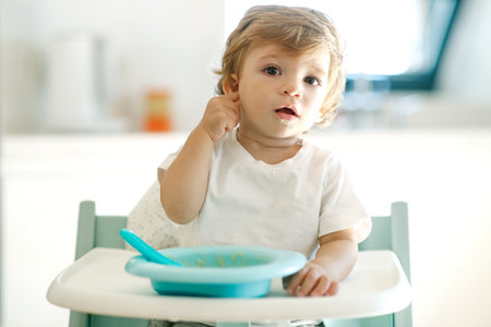 Baby eating. A small child eats at home by himself. High quality photoの写真素材