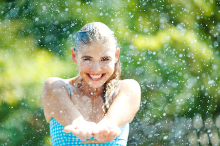 Woman with splashes of water in nature. High quality photoの写真素材