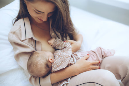 The woman is breastfeeding the baby. Young mom feeds the baby. High quality photo