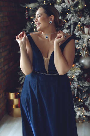Woman at Christmas. Fat woman in a beautiful dress for a holiday. High quality photoの写真素材