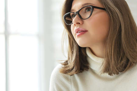 Woman with poor eyesight. A beautiful girl wears glasses to improve her vision. High quality photoの写真素材