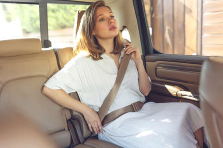 Woman in the car. Safety, fasten your seat belt. High quality photoの写真素材