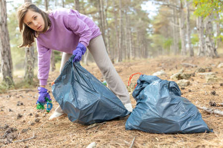 A woman removes rubbish in nature. High quality photoの写真素材