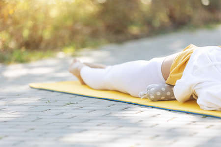 The woman put the roller under her back. Prevention of back pain. High quality photoの写真素材