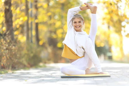 Woman practices yoga in the park. Girl in sports. High quality photoの写真素材