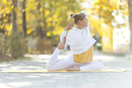 Woman practices yoga in the park. Girl in sports. High quality photoの写真素材