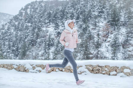 The woman goes in for sports. The girl runs in the winter. High quality photoの写真素材