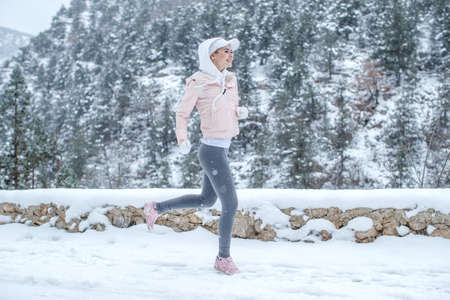 The woman goes in for sports. The girl runs in the winter. High quality photoの写真素材