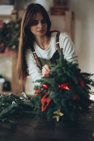 A woman makes a Christmas tree with her own hands. High quality photoの写真素材