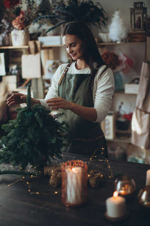 A woman makes a Christmas tree with her own hands. High quality photoの写真素材