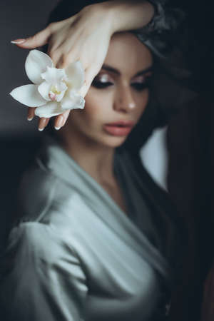 Beautiful woman holding a flower in her hand. High quality photoの写真素材